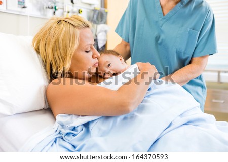Medical professional assisting mother with skin to skin care in the hospital
