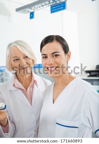 Portrait of confident female researcher with colleague in hospital