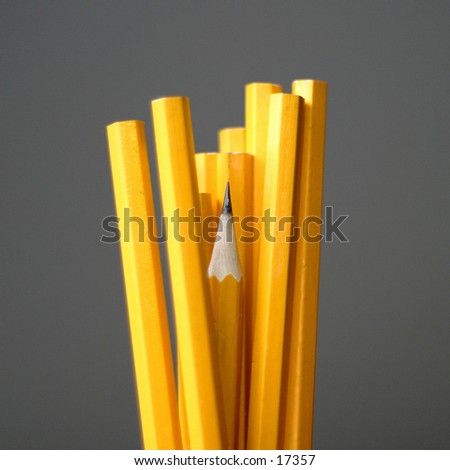 A group of pencils crowding a sharpened pencil which is a little bit lower.