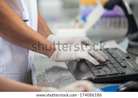 Cropped image of male technician using computer in medical laboratory