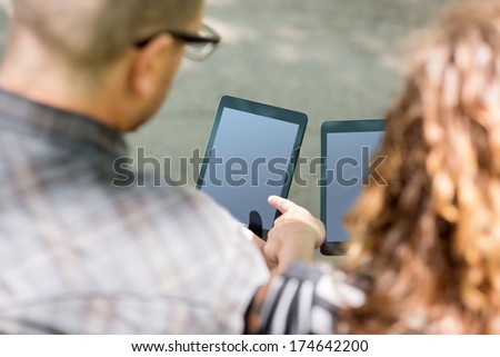 High angle view of university students using digital tablets at campus