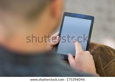 Cropped image of male university student using digital tablet at campus