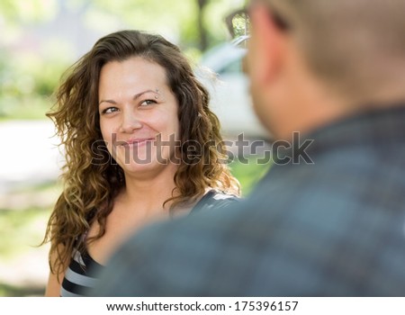 Selective focus of female university student looking at male friend on campus