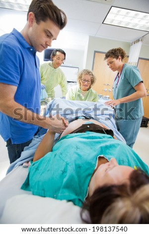 Mid adult man holding woman\'s hand during delivery in hospital room
