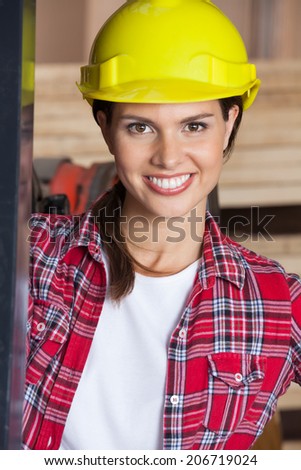 Closeup portrait of confident female engineer wearing hardhat in workshop