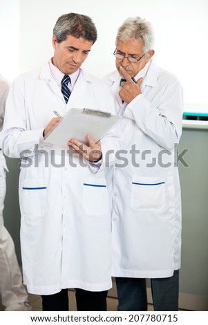 Male researcher explaining colleague in laboratory