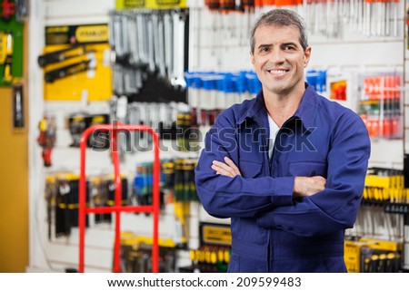 Portrait of confident worker with arms crossed standing in hardware shop