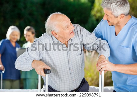 Male and female nurses helping senior people in nursing home