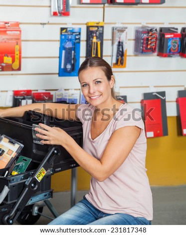 Portrait of smiling mid adult woman buying tools in hardware store