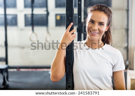 Portrait of smiling female athlete standing at gym