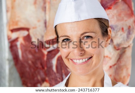 Closeup portrait of happy female butcher in shop