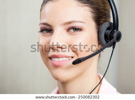Closeup portrait of female customer service agent wearing headset in office
