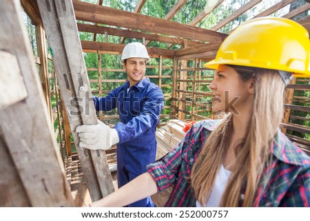 Male and female construction workers in wooden cabin at site