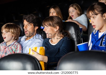 Amazed families watching movie in cinema theater