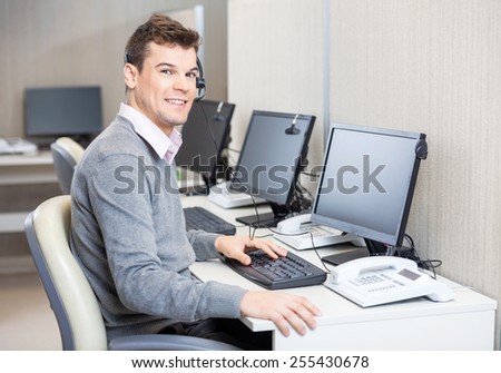 Portrait of young male customer service representative working in office