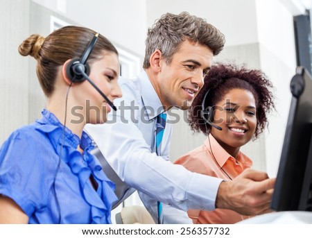Manager explaining something to his employees in call center