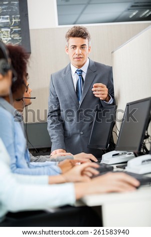 Confident manager discussing with customer service representatives in office