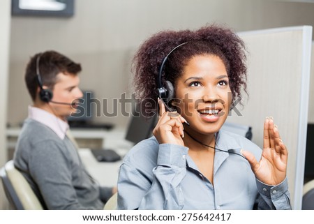 Young female call center agent speaking with costumer at office