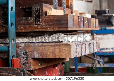 Closeup of papers in wooden press machine at factory
