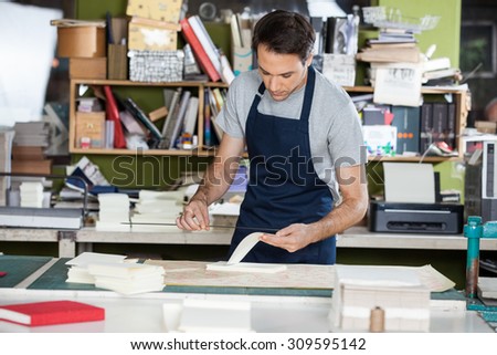 Mid adult male worker working at table in paper industry