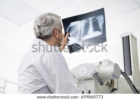 Male Doctor Analyzing Chest X-ray In Examination Room Foto d'archivio © 