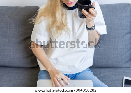 High view of beautiful girl drinking an hot drink while typing keyboard horizontal composition