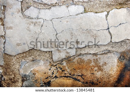 Cracked and broken and wet cement floor.