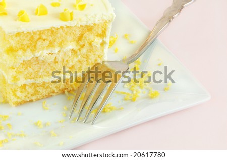 Lemon cake with a fork on a white plate.