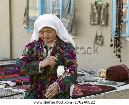 BUKHARA, UZBEKISTAN - MARCH 21: Traditionally clouded woman posing for tourist  on March 21, 2012 near Bukhara, Uzbekistan. Uzbekistan has great potential for an expanded tourism industry.
