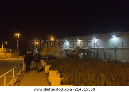 BETHLEHEM, PALESTINE - January 2: Unidentified people passing the wall between Israel and Palestine on Januray 2, 2013 in Bethlehem, Palestine.