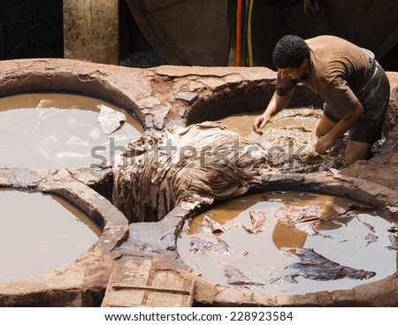 FEZ, MOROCCO - JULY 19: Worker  in the tannery souk of weavers on July 19, 2014 in Fez, Morocco. The tannery souk of weavers is the most visited part of the 2000 years old city.