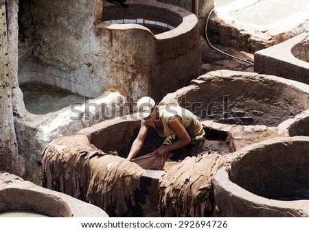 FEZ, MOROCCO - JULY 19: Workers  in the tannery souk of weavers on July 19, 2014 in Fez, Morocco. The tannery souk of weavers is the most visited part of the 2000 years old city.
