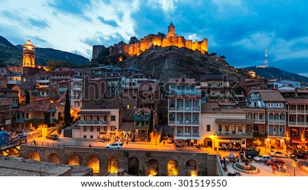TBILISI, GEORGIA - JULY 18, 2015: Night view of the georgian capital\'s downtown, behind the medieval Narikala fortress.