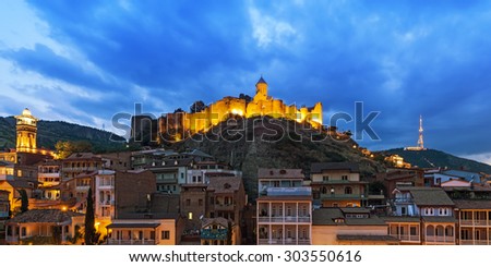 TBILISI, GEORGIA - JULY 18, 2015: Night view of the georgian capital\'s downtown, behind the medieval Narikala fortress.