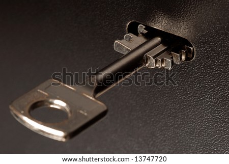 Puting a key in the lock of a safe.