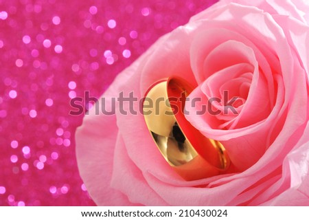 Golden ring in pink rose on pink sparkle background