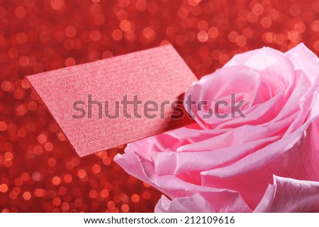 Pink rose with red greeting card on red sparkle background