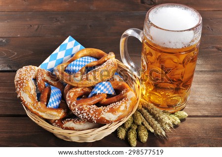 original bavarian Oktoberfest salted soft pretzels in a basket with beer from Germany on wooden board
