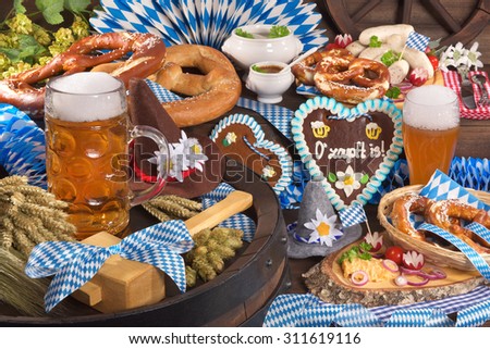 All typical German Bavarian symbols in one picture. Gingerbread heart with â??The beer is tappedâ?? text, soft pretzels, Bavarian veal sausage and beer.