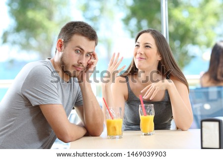 Bored man listening her friend talking in a bar or hotel on the beach Сток-фото © 