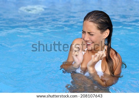 Woman complaints while bathing in a cold water of a swimming pool