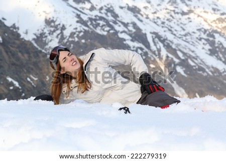 Skier woman hurt lying in the snow of a high mountain