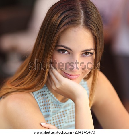 Portrait of a confident woman with perfect skin looking at camera with an unfocused background