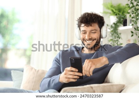 Similar – Image, Stock Photo Man with earbuds using tablet and laptop at table