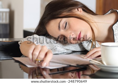 Tired overworked woman resting while she was working writing notes