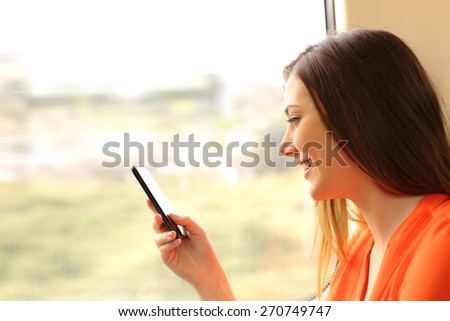 Passenger using a mobile phone in a train or bus beside the window