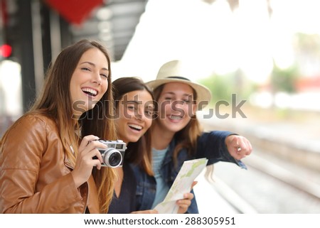 Group of three traveler girls traveling and waiting in a train station platform