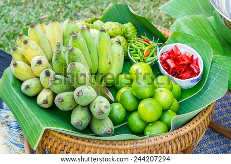 Raw Banana and Lemons on Green Banana leafs and chili on tray, Smiley-face vegetables on tray