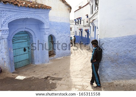 CHEFCHAOUEN, MOROCCO, NOVEMBER 20: kid staying on street of the Blue city of Chefchaouen, city founded in 1471 North of Morocco, 2013