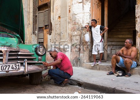 HAVANA - FEBRUARY 25: Unkown man washing his old classic car on February 25, 2015 in Havana. These vintage cars are an iconic sight of the island